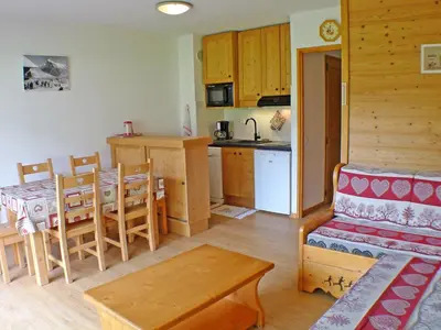 a kitchen and living room with a table and a couch at Appartement de 6 personnes avec terrasse, parking et Wi-Fi - FR-1-629-25 in Samoëns