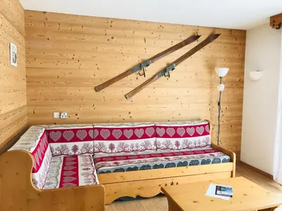 a bed in a room with a wooden wall at Appartement de 6 personnes avec terrasse, parking et Wi-Fi - FR-1-629-25 in Samoëns