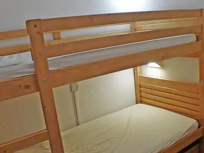 a wooden bunk bed with the top level of it at Appartement de 6 personnes avec terrasse, parking et Wi-Fi - FR-1-629-25 in Samoëns