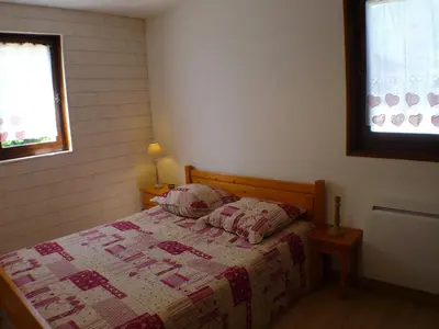 a bedroom with a bed with a quilt on it at T2 calme à Samoëns, terrasse et parking pour 4-6 pers. - FR-1-629-16 in Samoëns