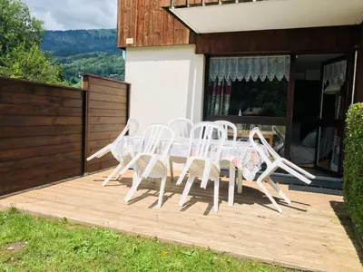 a group of white chairs and a table on a deck at T2 calme à Samoëns, terrasse et parking pour 4-6 pers. - FR-1-629-16 in Samoëns