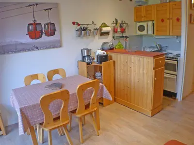 a kitchen with a table and chairs and a kitchen with a table and a kitchen at Appartement 5 pers. avec balcon privé et parking à Samoëns - FR-1-629-20 in Samoëns