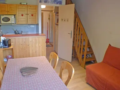 a kitchen and dining room with a table and a staircase at Appartement 5 pers. avec balcon privé et parking à Samoëns - FR-1-629-20 in Samoëns