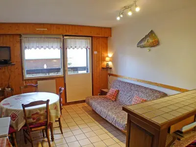 a living room with a couch and a table in a room at Appartement lumineux 2 pièces cabine, animaux admis, proche centre Samoëns - FR-1-629-22 in Samoëns