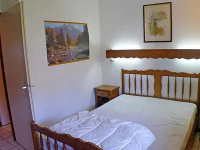 a bedroom with a bed and a painting on the wall at Appartement lumineux 2 pièces cabine, animaux admis, proche centre Samoëns - FR-1-629-22 in Samoëns