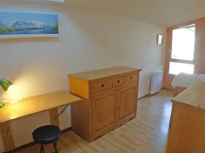 a room with a wooden desk and a table at Coquet 3 pièces lumineux, centre de Samoëns, animaux acceptés, wifi, parking - FR-1-629-23 in Samoëns