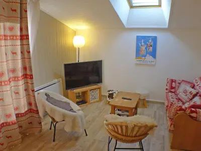a living room with a couch and a tv at Coquet 3 pièces lumineux, centre de Samoëns, animaux acceptés, wifi, parking - FR-1-629-23 in Samoëns