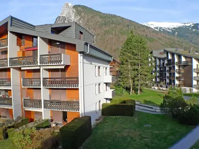 an apartment building with a mountain in the background at Coquet 3 pièces lumineux, centre de Samoëns, animaux acceptés, wifi, parking - FR-1-629-23 in Samoëns