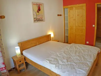a bedroom with a bed and a door with a lamp at Coquet 3 pièces lumineux, centre de Samoëns, animaux acceptés, wifi, parking - FR-1-629-23 in Samoëns
