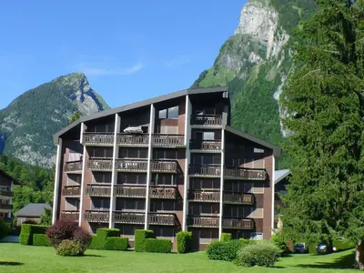 a building in front of a mountain at Appartement 2 pièces avec animaux admis, balcon et garage - FR-1-629-27 in Samoëns