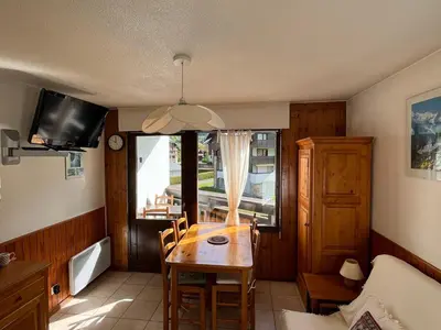 a dining room with a table and a window at Appartement 2 pièces avec animaux admis, balcon et garage - FR-1-629-27 in Samoëns