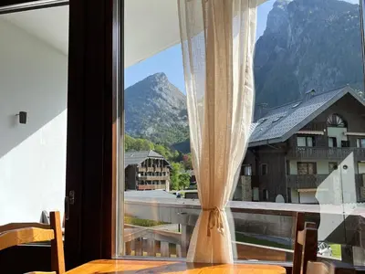 a window with a table and a view of a mountain at Appartement 2 pièces avec animaux admis, balcon et garage - FR-1-629-27 in Samoëns