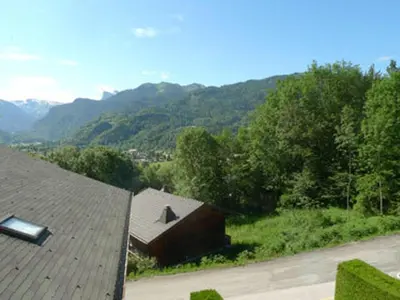 a view of a house with mountains in the background at Appartement calme à Samoëns, 2 chambres, animaux admis, proche centre - FR-1-629-24 in Samoëns