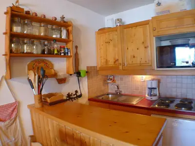 a kitchen with wooden cabinets and a sink and a microwave at Charmant duplex pour 6 pers. avec TV et parking à Samoëns. - FR-1-629-29 in Samoëns