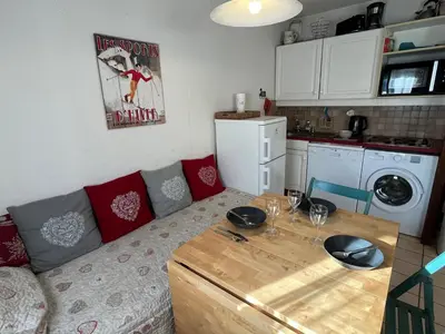 a living room with a couch and a table at Coquet studio RDC avec terrasse, animaux admis, étang Samoëns - FR-1-629-55 in Samoëns