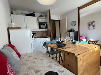 a kitchen with a table and a kitchen with a refrigerator at Coquet studio RDC avec terrasse, animaux admis, étang Samoëns - FR-1-629-55 in Samoëns