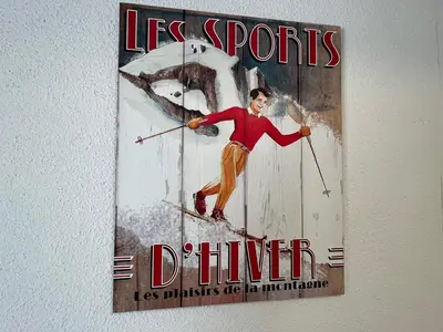 a poster of a man on skis on a wall at Coquet studio RDC avec terrasse, animaux admis, étang Samoëns - FR-1-629-55 in Samoëns