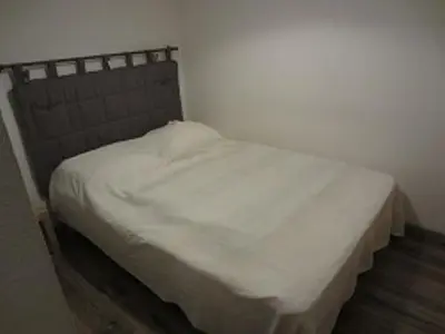 a bed with white sheets and a headboard in a room at Grand studio à Samoëns, animaux admis, parking, proche télécabine - FR-1-629-54 in Samoëns