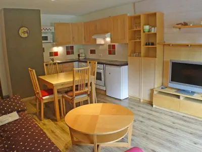 a kitchen and dining room with a table and a television at Grand studio à Samoëns, animaux admis, parking, proche télécabine - FR-1-629-54 in Samoëns