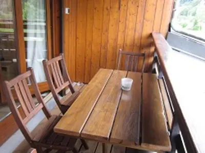 a wooden table with two chairs and a cup on it at Grand studio à Samoëns, animaux admis, parking, proche télécabine - FR-1-629-54 in Samoëns
