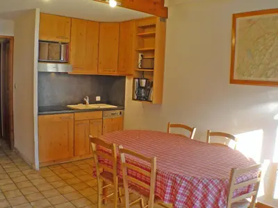 a kitchen with a table and a table and chairs at Appartement charme 5 pers., balcon, parking sous-sol - FR-1-629-38 in Samoëns
