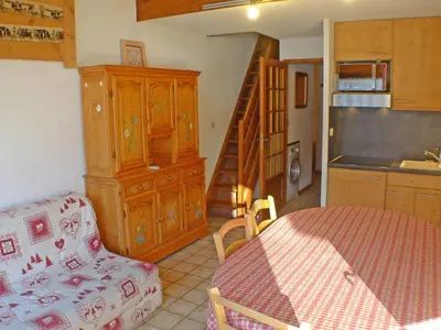 a kitchen with a table and a kitchen with a staircase at Appartement charme 5 pers., balcon, parking sous-sol - FR-1-629-38 in Samoëns