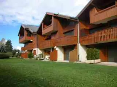 a large building with a green lawn in front of it at Appartement charme 5 pers., balcon, parking sous-sol - FR-1-629-38 in Samoëns
