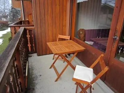 a table and two chairs on the porch of a house at Appartement charme 5 pers., balcon, parking sous-sol - FR-1-629-38 in Samoëns