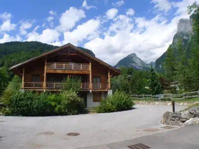 a log cabin with mountains in the background at 3 pièces calme à Samoëns avec parking privé, 4 couchages - FR-1-629-48 in Samoëns