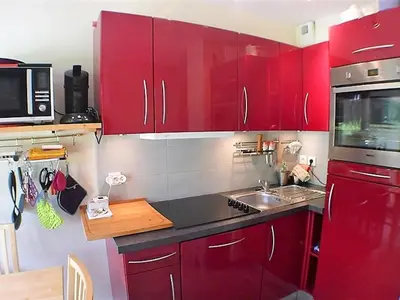 a kitchen with red cabinets and a sink and a microwave at 3 pièces calme à Samoëns avec parking privé, 4 couchages - FR-1-629-48 in Samoëns