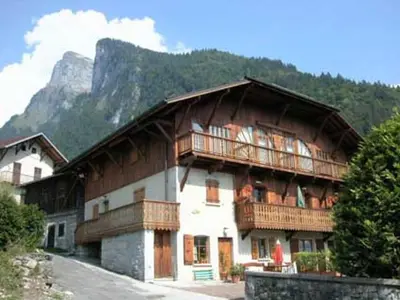 a large building with a balcony and a mountain at Appartement 3 pièces avec balcon et parking à Samoëns - FR-1-629-52 in Samoëns