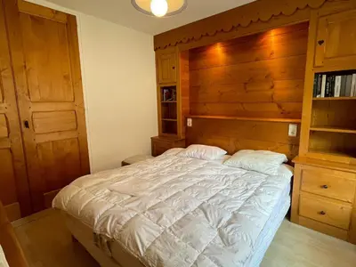 a bedroom with a large bed with a wooden headboard at Appartement 3 pièces à Samoëns, 6 pers., WIFI, Parking - FR-1-629-76 in Samoëns