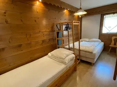 two beds in a room with wooden walls at Appartement 3 pièces à Samoëns, 6 pers., WIFI, Parking - FR-1-629-76 in Samoëns