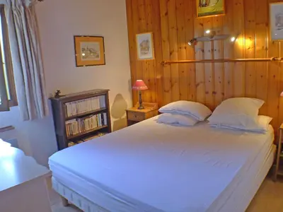 a bedroom with a large white bed with wooden walls at Charmant T3 calme à 500m du centre de Samoëns avec parking - FR-1-629-57 in Samoëns