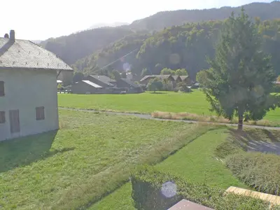 a view of a field with a house and a tree at Charmant T3 calme à 500m du centre de Samoëns avec parking - FR-1-629-57 in Samoëns