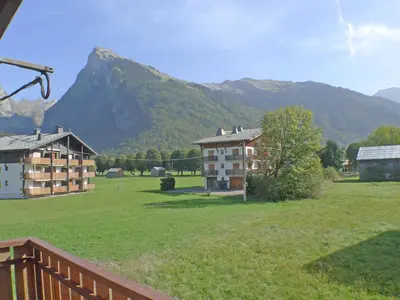 a large field with buildings and mountains in the background at Charmant T3 calme à 500m du centre de Samoëns avec parking - FR-1-629-57 in Samoëns