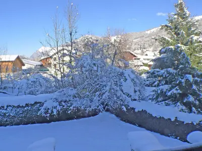 a red couch in a living room with a shelf at Studio cosy centre village, animaux admis, parking privatif - FR-1-629-66 in Samoëns