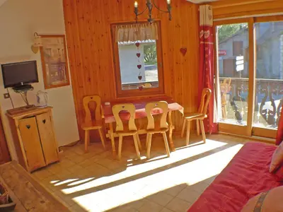 a living room with a red couch and a table at Appartement T2 avec mezzanine au cœur du village, animaux admis - FR-1-629-68 in Samoëns