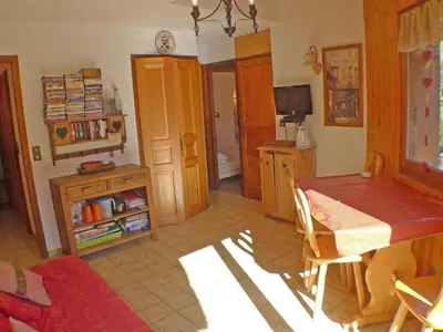 a dining room with a table and chairs and a television at Appartement T2 avec mezzanine au cœur du village, animaux admis - FR-1-629-68 in Samoëns
