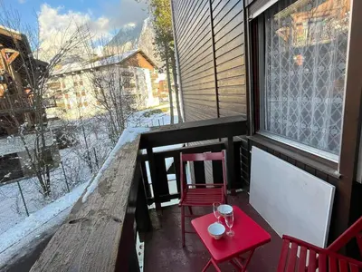 a red table and chairs on a balcony with a window at Studio cosy au centre de Samoëns, 4 pers, proche commodités - FR-1-629-65 in Samoëns
