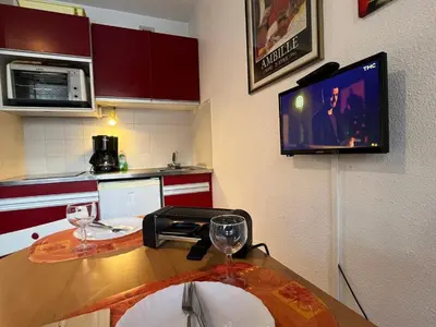 a kitchen with a table with wine glasses and a tv at Studio cosy au centre de Samoëns, 4 pers, proche commodités - FR-1-629-65 in Samoëns