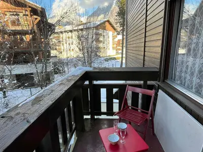 a red chair sitting on a balcony with a table at Studio cosy au centre de Samoëns, 4 pers, proche commodités - FR-1-629-65 in Samoëns