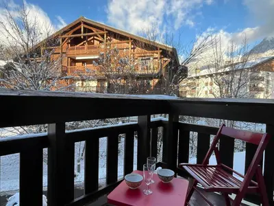 a table and chairs on a balcony with a lodge at Studio cosy au centre de Samoëns, 4 pers, proche commodités - FR-1-629-65 in Samoëns