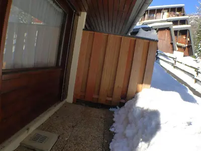 a pile of snow next to a wooden door at Studio calme pour 4 pers. avec terrasse à Samoëns - FR-1-629-30 in Samoëns