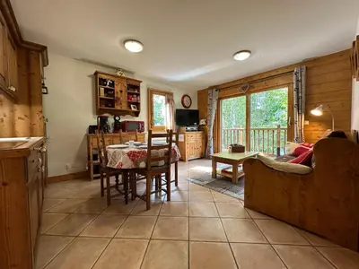 a kitchen and living room with a table and chairs at Appartement T3 cosy avec balcon au centre de Samoëns - FR-1-624-31 in Samoëns