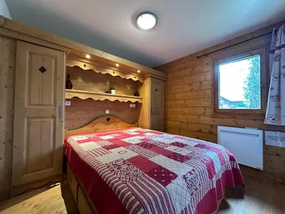 a bedroom with a bed in a wooden cabin at Appartement T3 cosy avec balcon au centre de Samoëns - FR-1-624-31 in Samoëns
