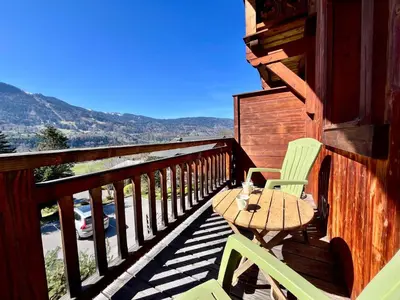 a deck with a table and chairs on a cabin at Appartement moderne 3 chambres avec balcon à Samoëns - FR-1-624-25 in Samoëns