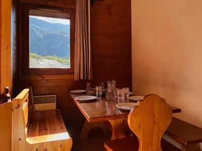 a dining room with a wooden table and a window at Appartement en duplex avec piscine à Samoëns - FR-1-624-12 in Samoëns