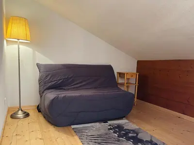 a bed in the corner of a room with a lamp at Appartement en duplex avec piscine à Samoëns - FR-1-624-12 in Samoëns