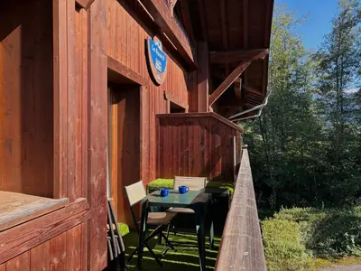 a small table in the outside of a building at Appartement en duplex avec piscine à Samoëns - FR-1-624-12 in Samoëns
